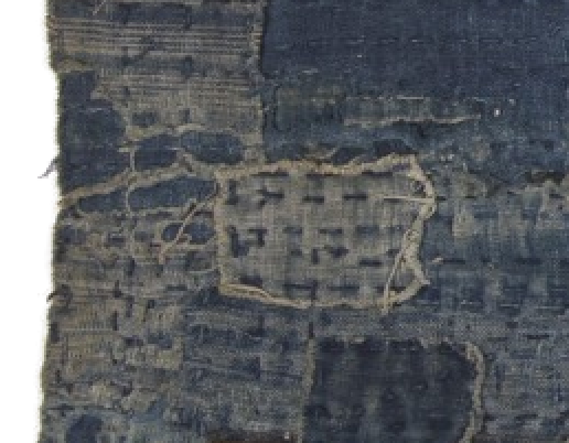 Fragment of boro cloth: mended indigo cotton, patched and stitched.